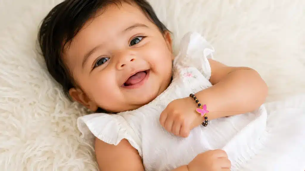 Newborn baby wearing a handcrafted gold nazariya bracelet from Sapphire Sorbet